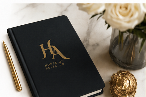 House of Asake branded black notebook and gold pen